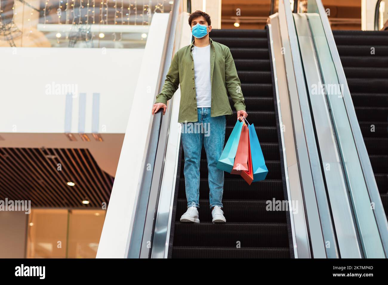 Männlicher Käufer Beim Einkaufen, Der Auf Einer Beweglichen Treppe In Der Mall Posiert Stockfoto