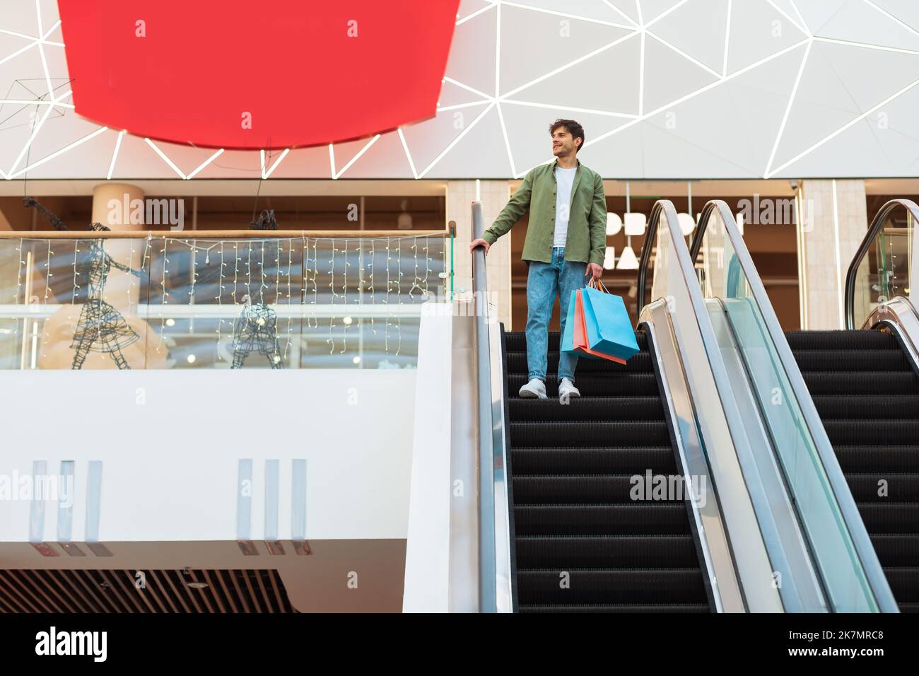 Mann Einkaufen In Der Mall Hält Taschen Stehen Auf Beweglichen Treppen Stockfoto