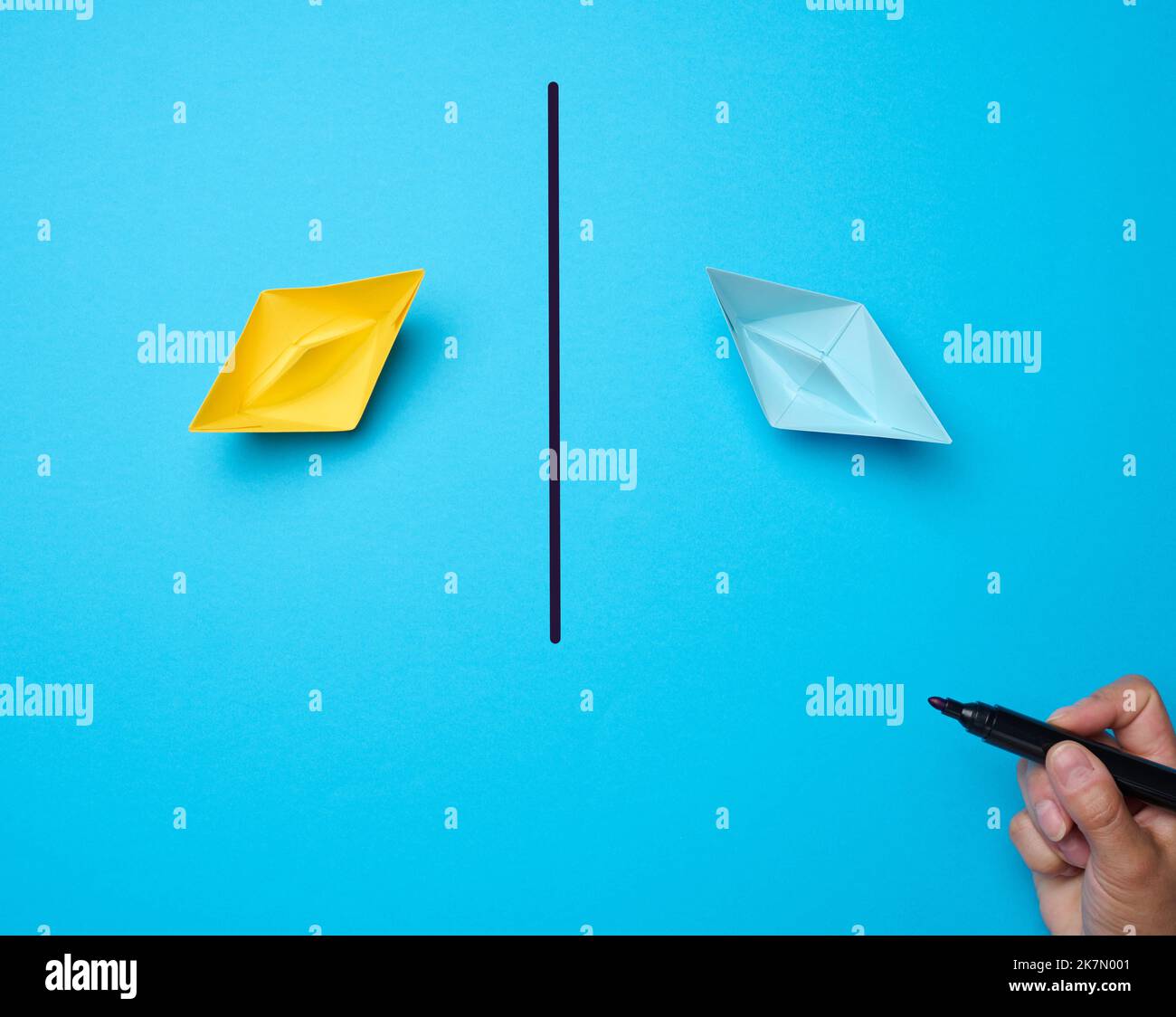 Zwei Papierboote und eine Linie mit einem Marker dazwischen. Abstimmungs-Konzept, Konflikt stoppen Stockfoto