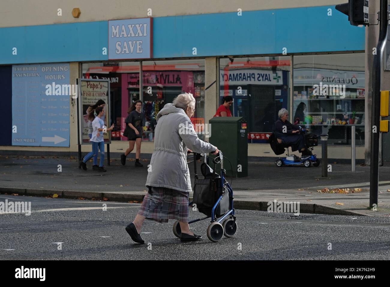 Ein Rentner im Alter, der die Straße in Weston super Mare, Großbritannien, überquert. Stockfoto