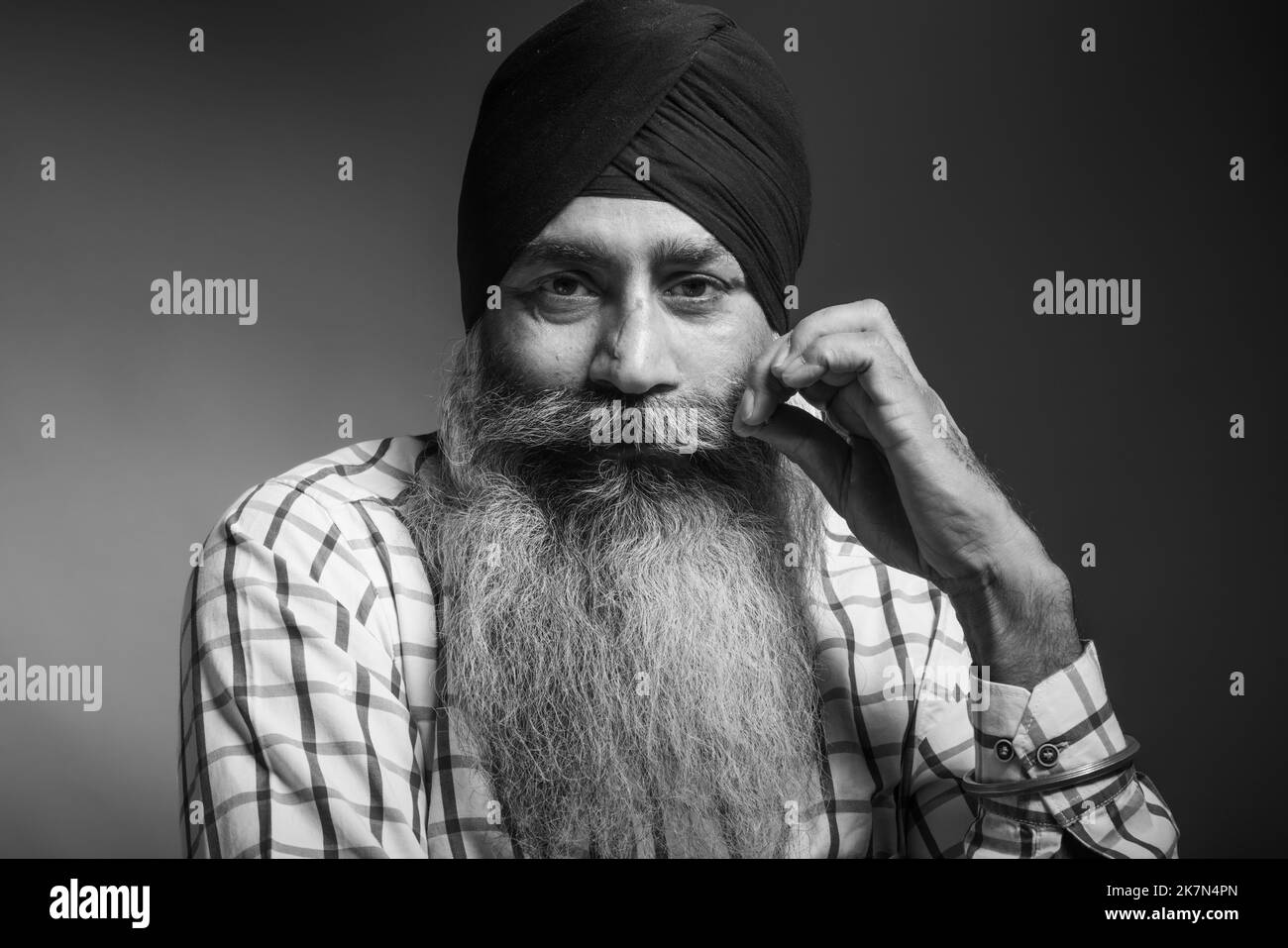 Eine Graustufenaufnahme eines indischen Mannes mit langem Bart und Turban Stockfoto