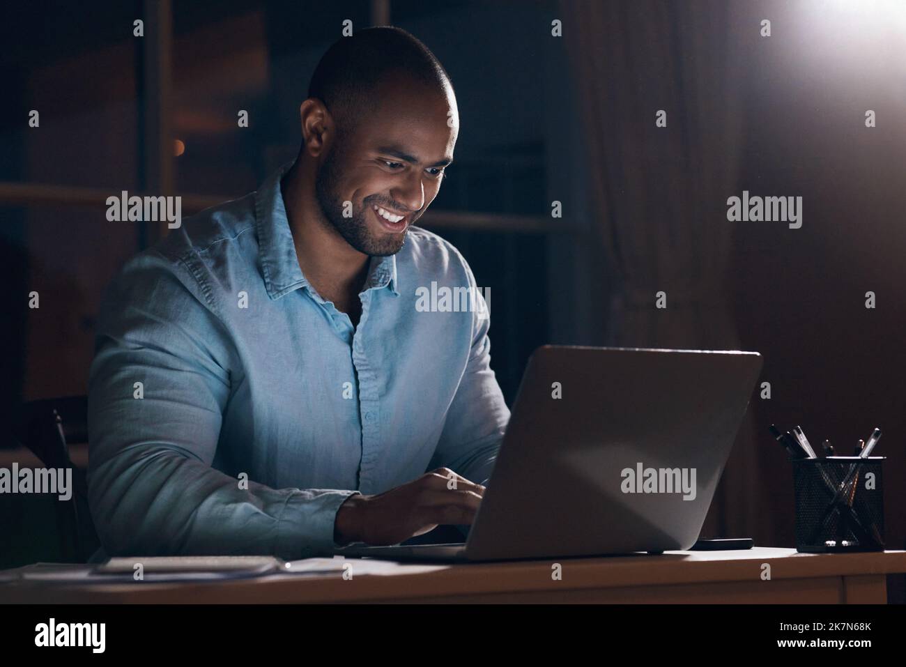 Das Mitternachtsöl verbrennen. Ein junger Geschäftsmann, der seinen Laptop benutzt, während er spät in der Nacht arbeitet. Stockfoto