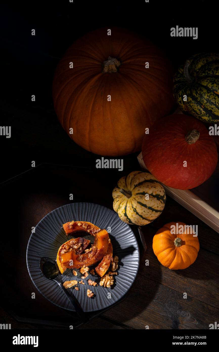 Dunkel launisch bildlich Stillleben von Herbst gerösteten Butternut Kürbis mit Zimt, Walnüssen und Honig bestäubt Stockfoto