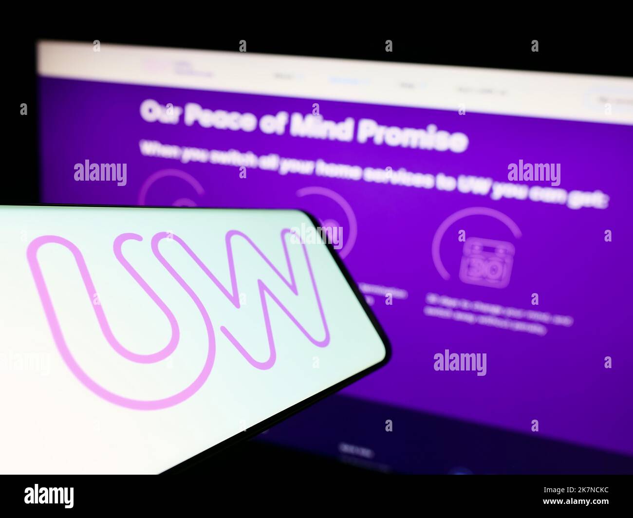 Smartphone mit Logo der britischen Firma Utility Warehouse (UW) auf dem Bildschirm vor der Business-Website. Konzentrieren Sie sich auf die Mitte des Telefondisplays. Stockfoto