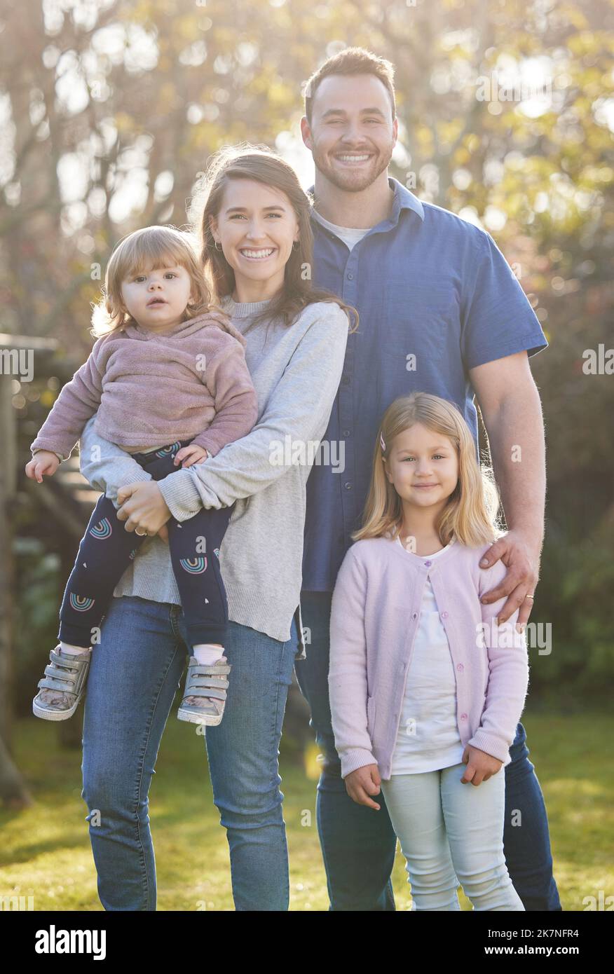 Familientag. Beschnittenes Porträt einer liebevollen jungen vierköpfigen Familie, die zu Hause im Garten posiert. Stockfoto