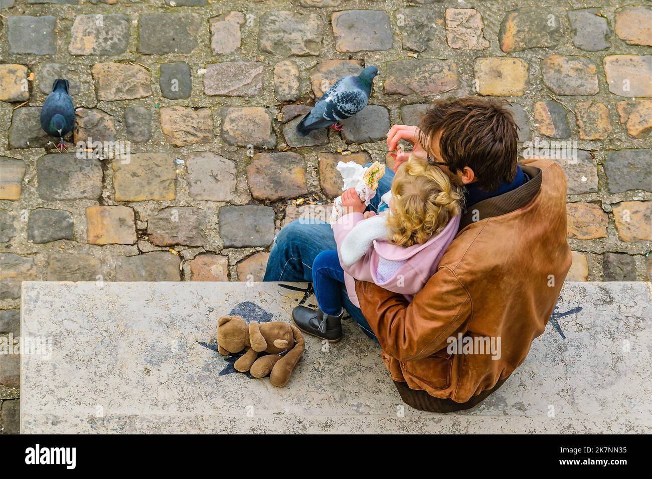 Draufsicht geschossen junger Vater Fütterung Tochter im öffentlichen Park, paris, frankreich Stockfoto