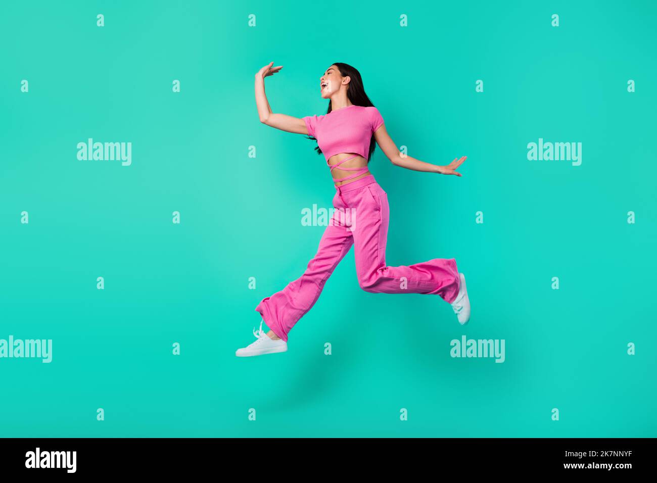 In voller Länge Profil Seite Foto von aktiven energischen Weibchen fühlen sich frei springen isoliert auf blauem Hintergrund Stockfoto