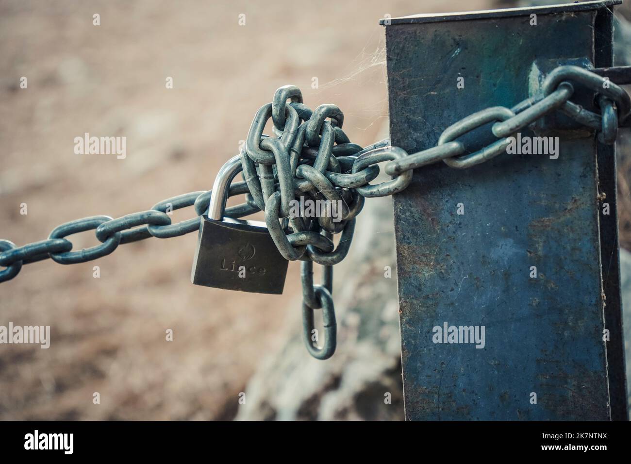 Metallkette mit Schloss, Blockierung des Wegeingangs im Berggebiet, Spanien. Stockfoto