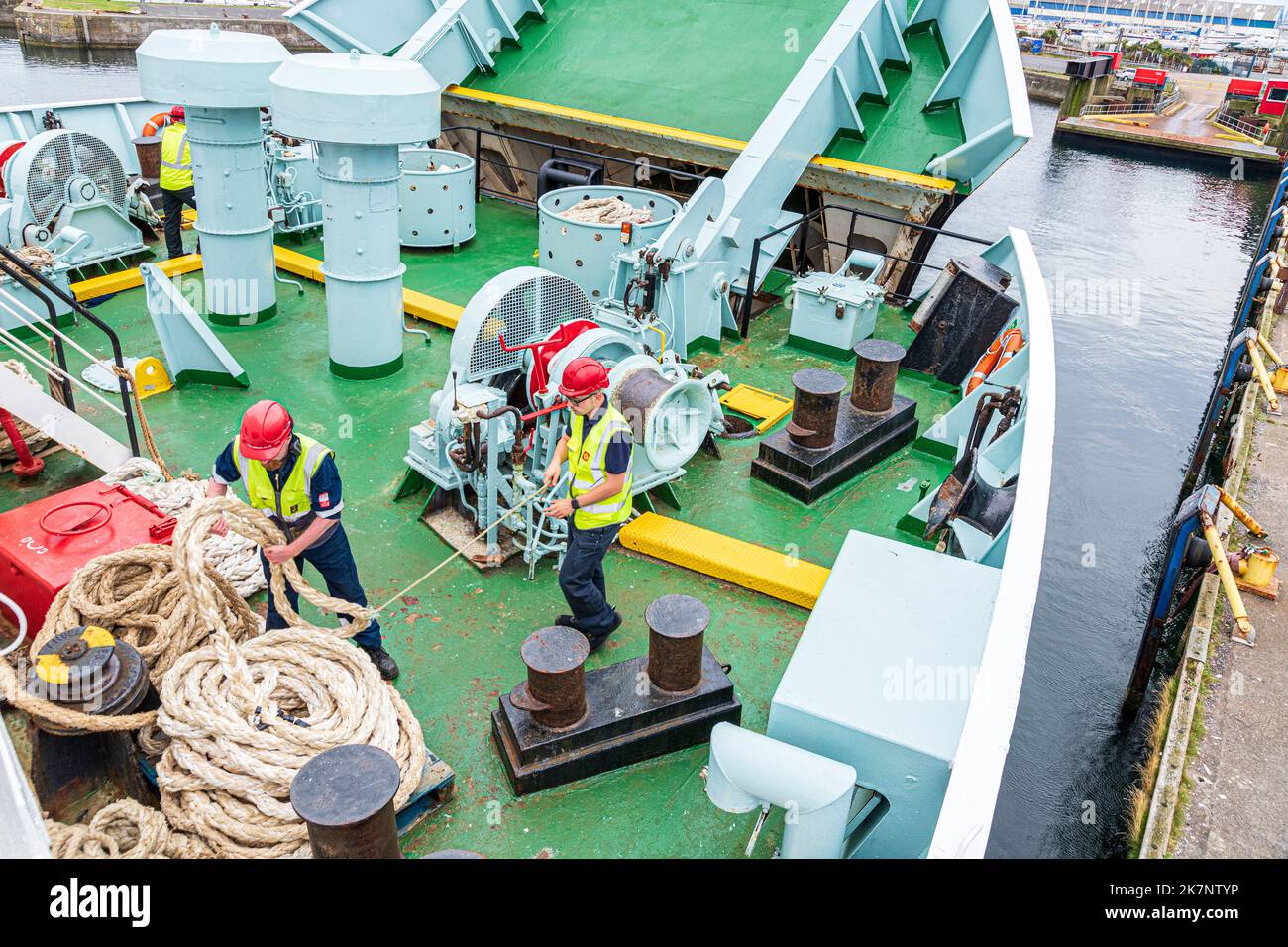 Deckshände, die Festmacherseile auf der CalMac-Fähre Isle of Arran aufwickeln, verlassen Ardrossan, North Ayrshire, Schottland, Großbritannien, um nach Campbeltown zu gelangen Stockfoto