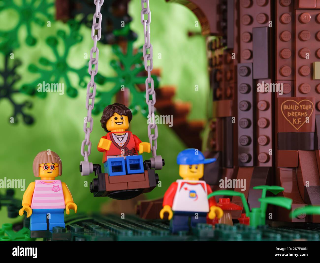 Tambow, Russische Föderation - 17. September 2022 drei Lego-Minifiguren unter dem Baum. Ein Mädchen sitzt auf der Schaukel, ein anderes Mädchen und ein Junge sind es Stockfoto