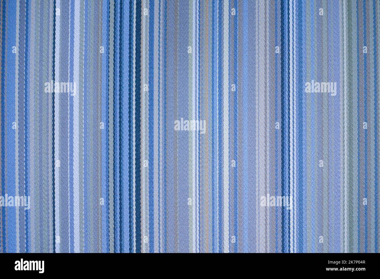Farbenfroher, blauer Stoffhintergrund mit weichen verblassten, regenbogenfarbenen vertikalen Streifen Stockfoto
