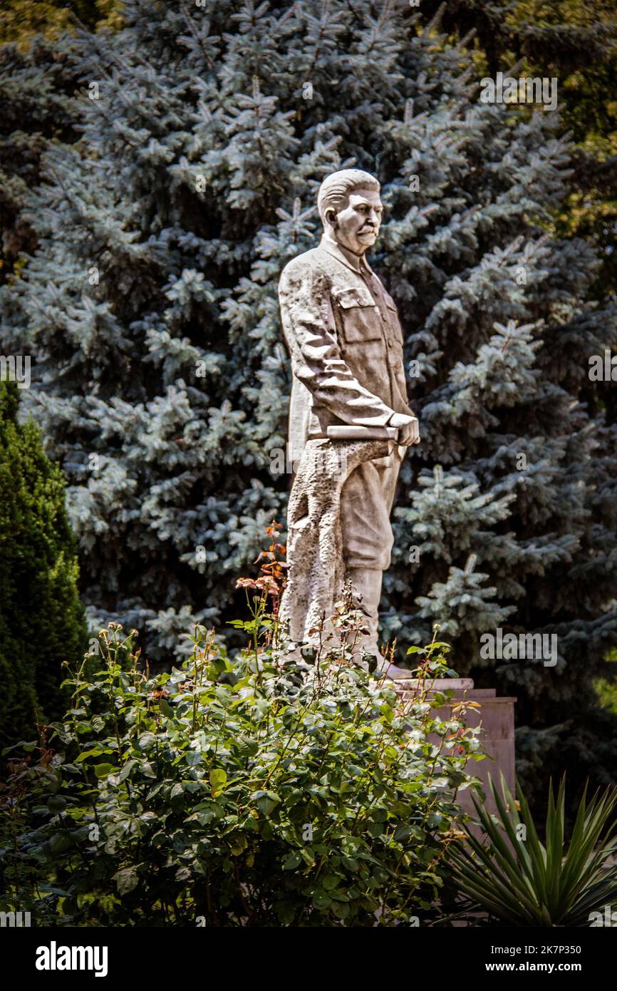 2019 07 20 Gori Georgia - Marmorstatue des Diktators Joseph Stalin im Garten des Museums über seinem Geburtsort erbaut - Blaue Fichte hinter Statue ist blu Stockfoto