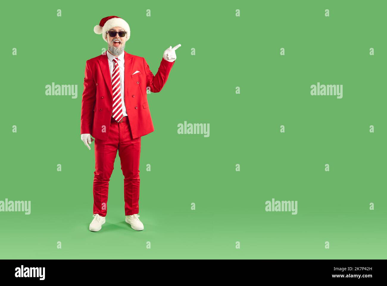 Lustiger Weihnachtsmann in roter Farbe zeigt mit seinem Zeigefinger auf eine leere Stelle für Text Stockfoto