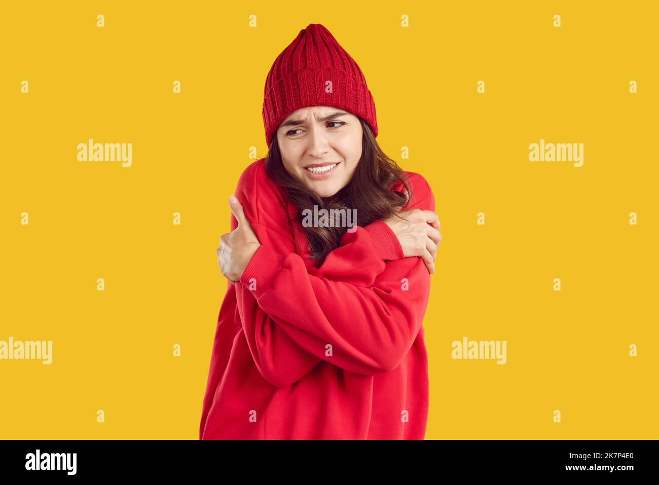 Frau im warmen Hut und Sweatshirt eiskalt und traurig an kalten Herbst- oder Wintertagen Stockfoto