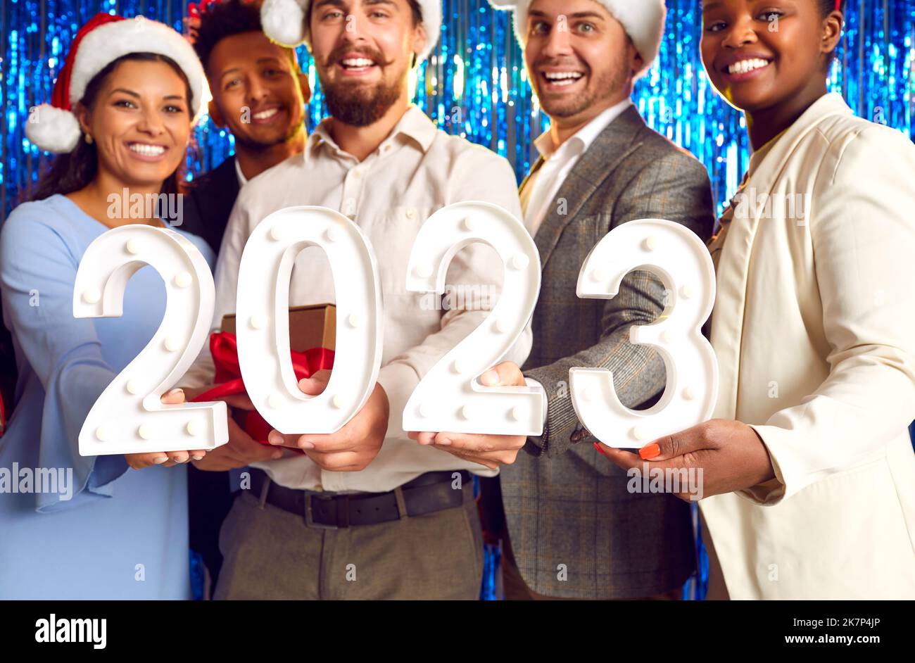 Team von glücklichen, fröhlichen und vielfältigen Menschen mit 2023 Ziffern auf der Firmenneujahresfeier Stockfoto