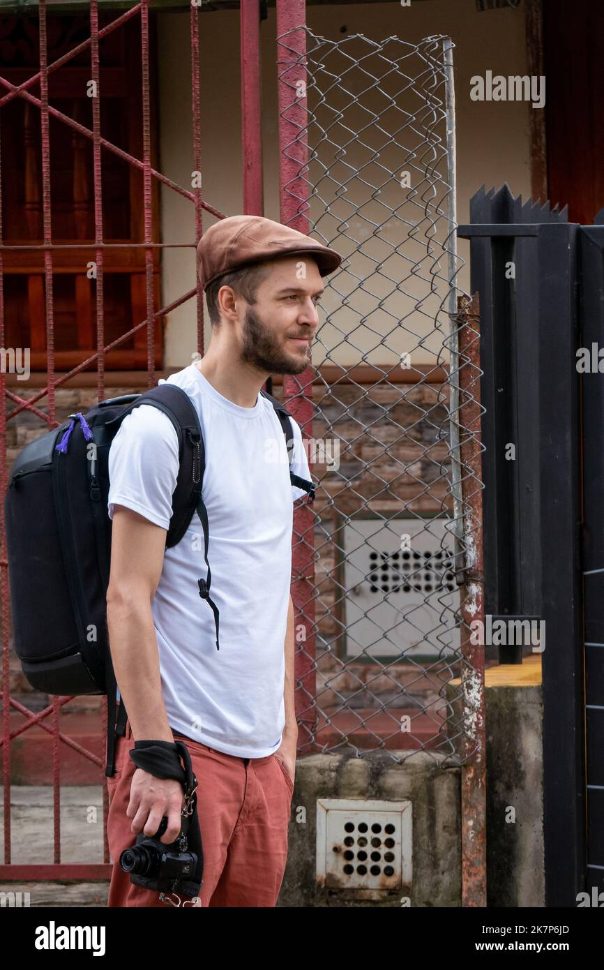 Junger weißer Mann mit Bart, der eine braune Mütze und ein Hemd mit der Aufschrift „Rette Tiere“ beim Spaziergang in der Stadt verwendet Stockfoto