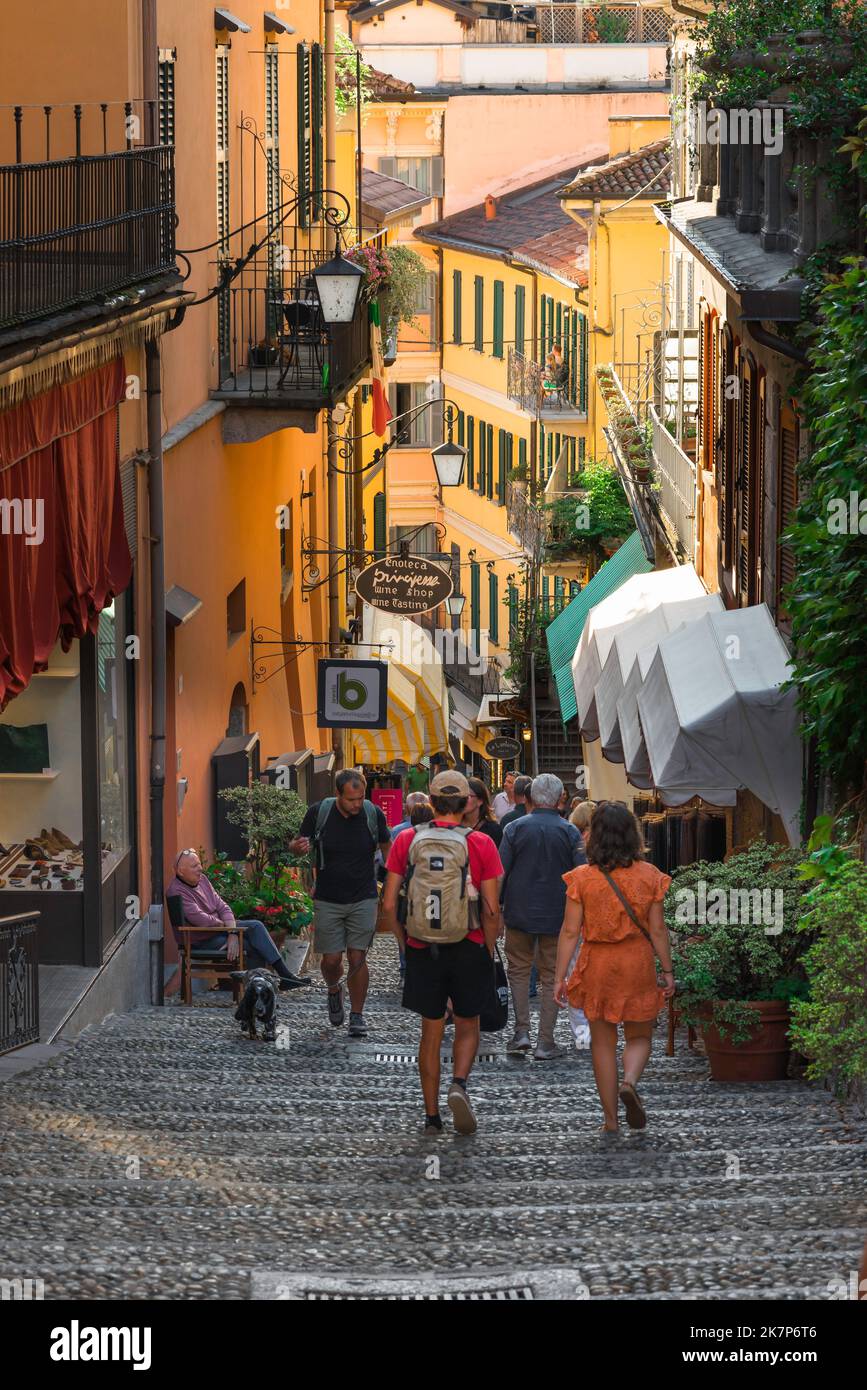 Bellagio Straße Altstadt, Blick auf Menschen, die in einer malerischen alten Straße im Zentrum von Bellagio, einer beliebten Stadt am Comer See, Italien, spazieren gehen Stockfoto