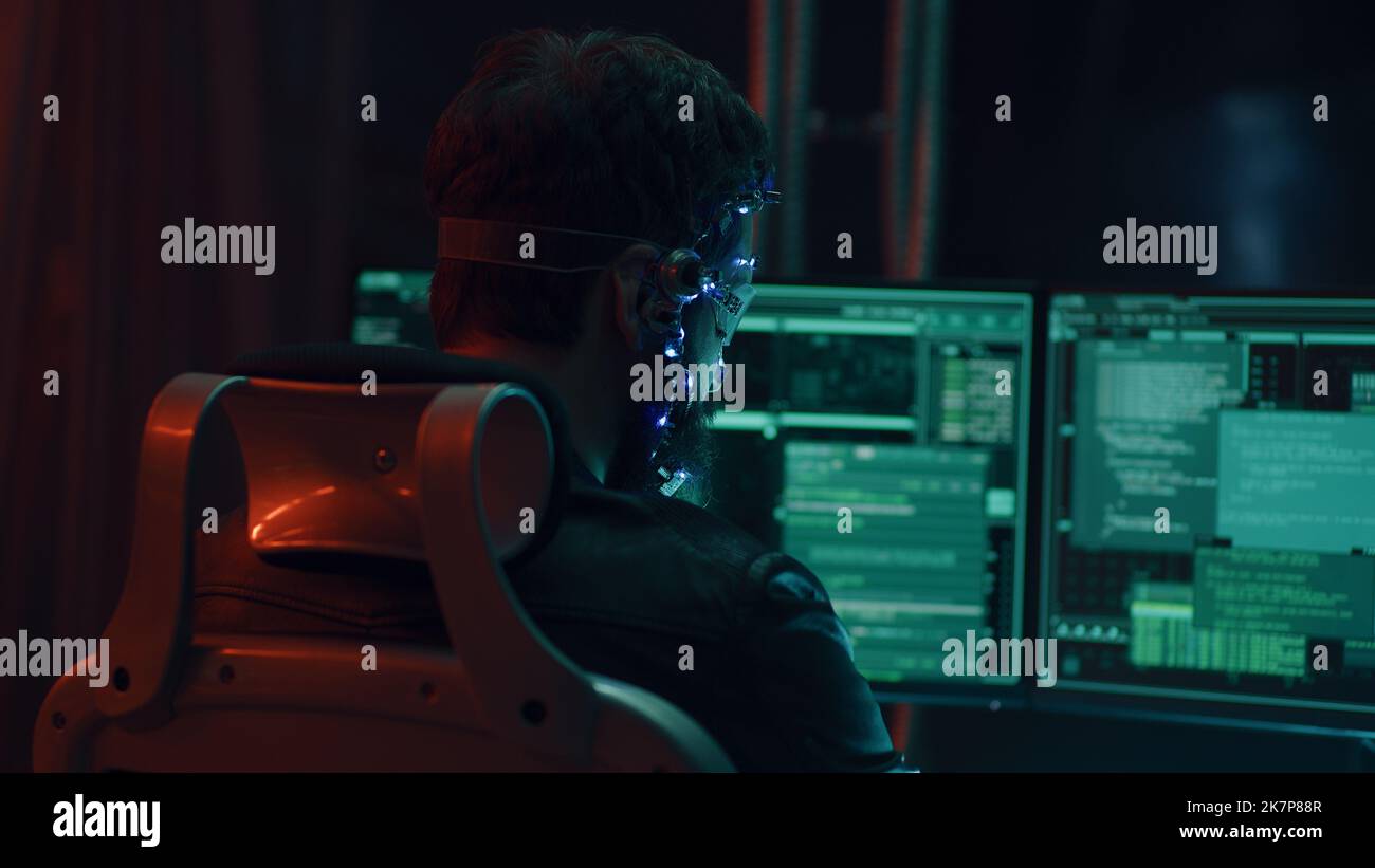 Rückansicht eines Brünetten Typen, der ein futuristisches Headset mit LED-Leuchten trägt, die Programme anschließt und Code mithilfe eines mehrfachen Computerbildschirms entwickelt. Cypperpunk-Stil. Sci-Fi-Hintergrund. Neonlichter. Stockfoto