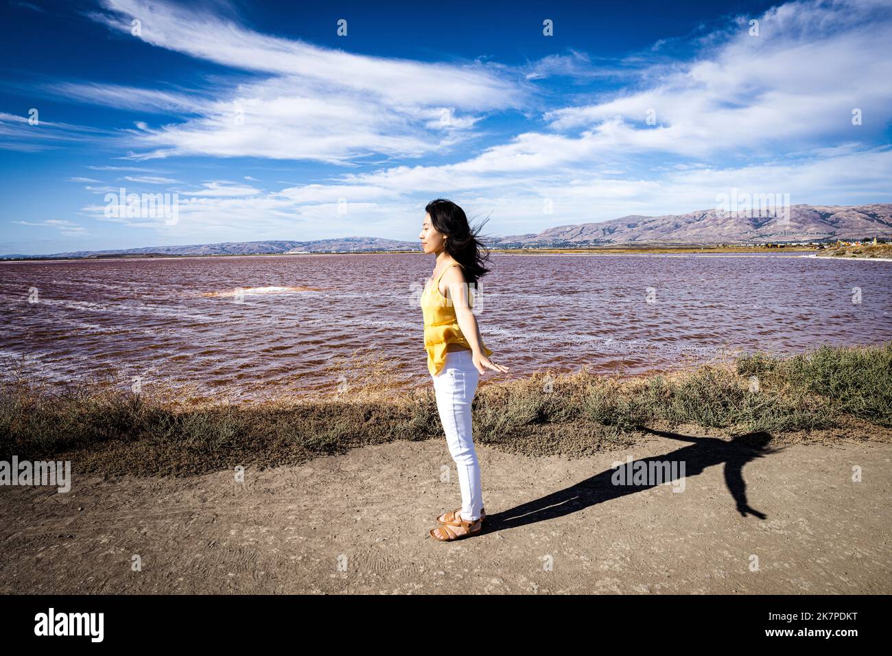 Porträt einer jungen Frau, die während der roten Flut in der Nähe der Küste der Bucht von San Francisco spaziert Stockfoto