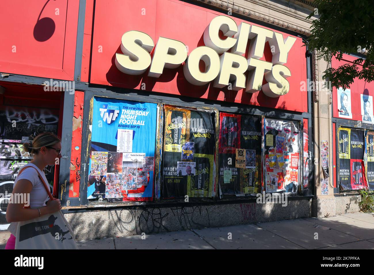 Eine Person geht an dem verschlossenen und geschlossenen Sportartikelgeschäft City Sports auf der Commonwealth Ave in Boston, Massachusetts, vorbei Stockfoto