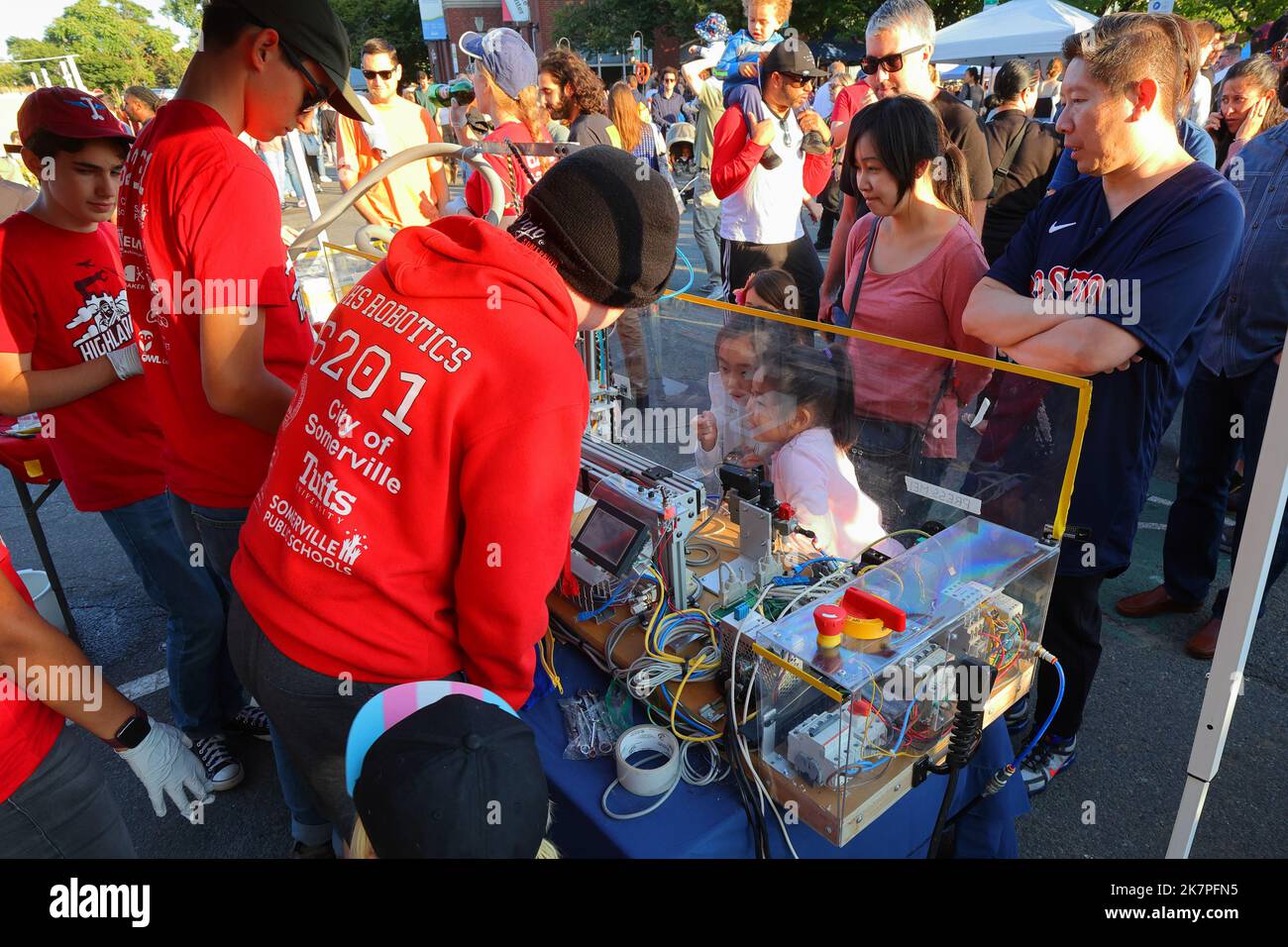 Zwei Kinder untersuchen den S'moresBot, der vom Roboterteam der Somerville Public Schools Highlanders 6201 beim Fluff Festival in Somerville, Massachusetts, gebaut wurde. Stockfoto
