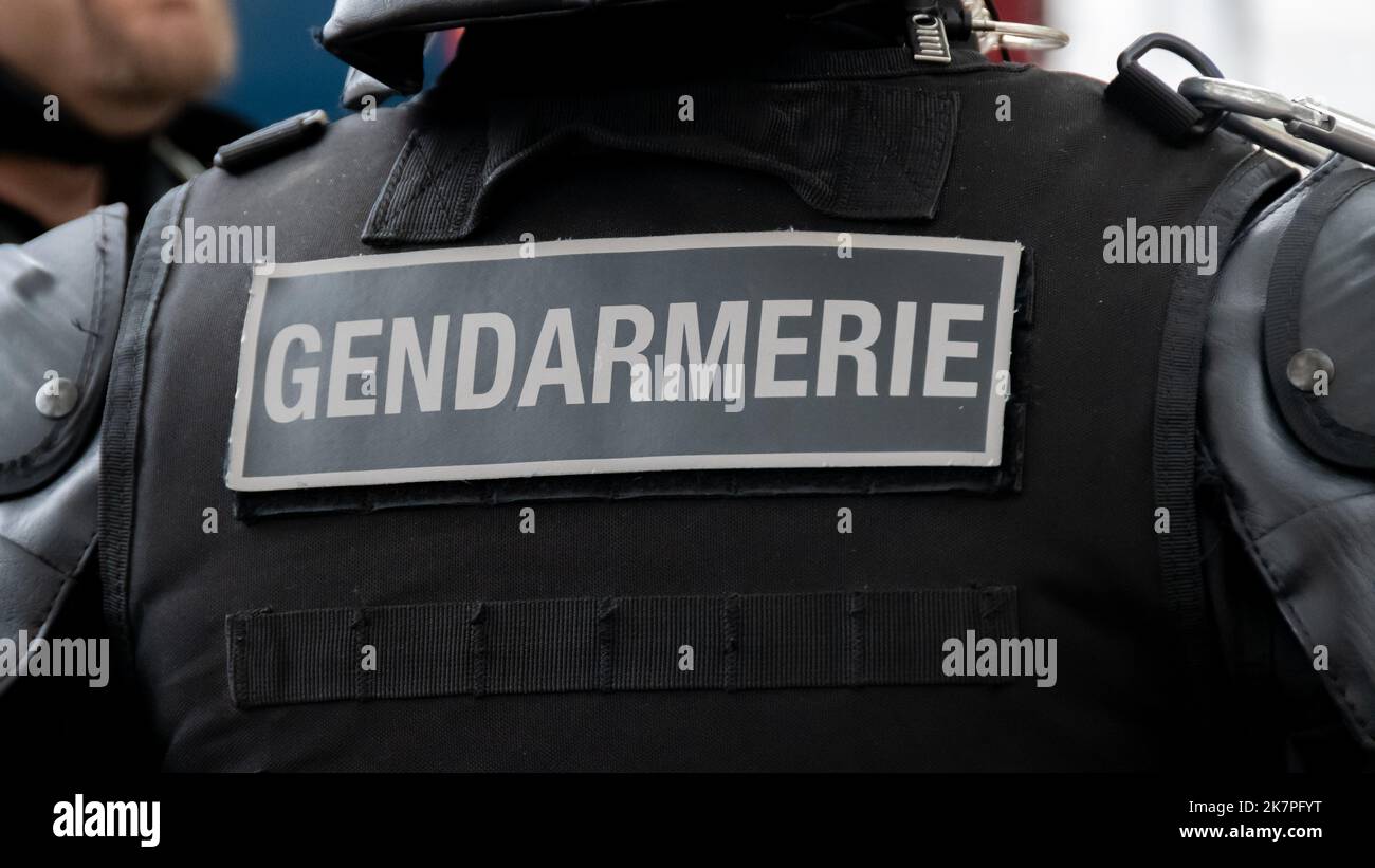 Nahaufnahme der „GENDARMERIE“-Markierung auf der Rückseite einer kugelsicheren Weste, die von einem französischen Gendarmen auf einer Straße in Paris, Frankreich, getragen wird Stockfoto