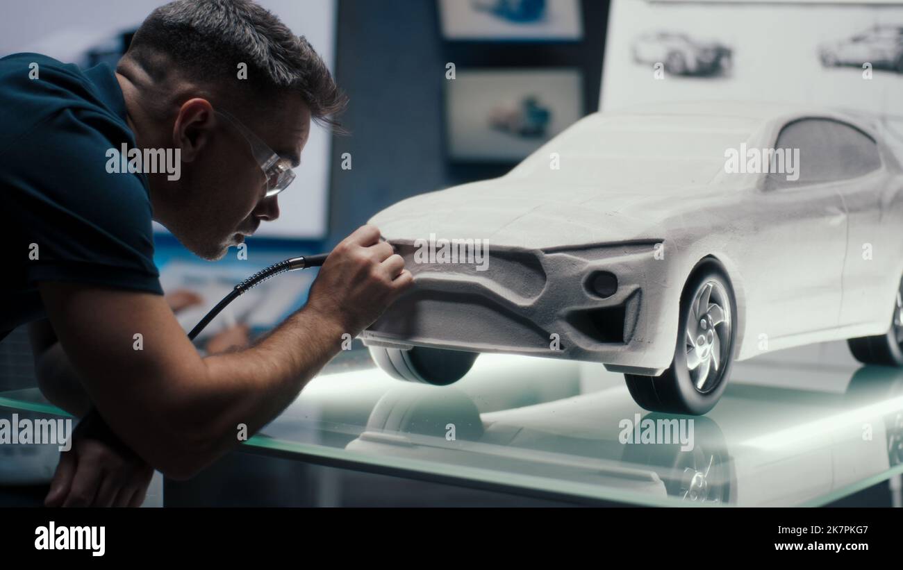 Der Automobilingenieur nimmt die Konstruktionskorrekturen an einer Prototypen-Skulptur vor und perfektioniert sie mit der Drehfräse-Werkzeugmaschine. Modell des Autos auf Glastisch in einem High-Tech-Labor platziert. Stockfoto