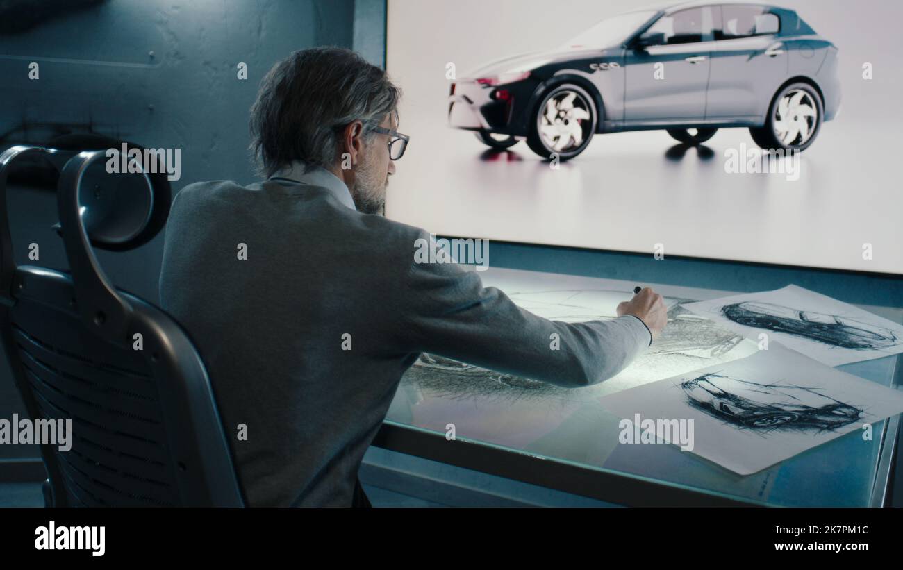 Automobilgrafiker zeichnet eine Skizze des Prototyps eines Autos mit digitaler Display-Grafik Touch sreen Tisch, mit Stylus-Stift in einem innovativen High-Tech-Labor. Stockfoto