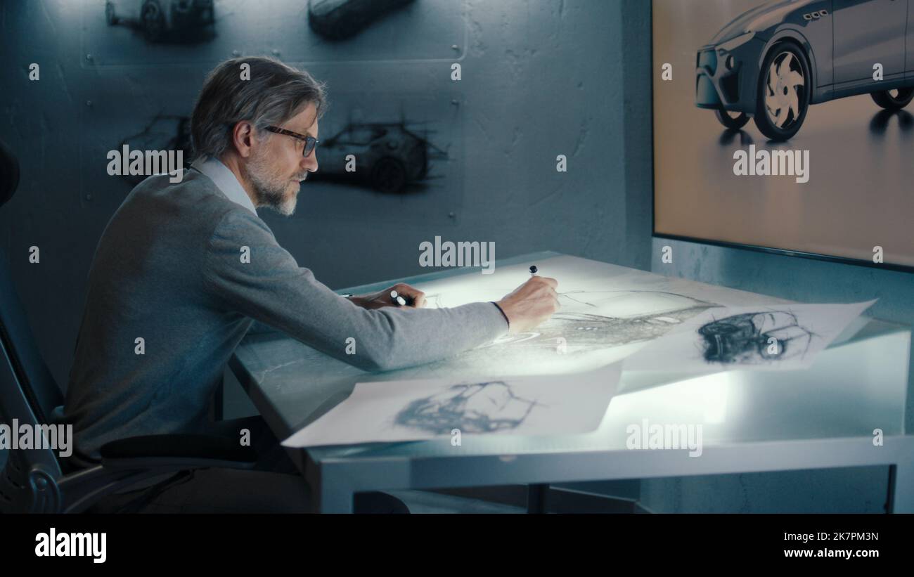 Ein Automobilingenieur und -Designer übergibt Skizzen eines Prototyps und nimmt Designkorrekturen mit einem digitalen Display-Grafik-Touch-Sreen-Tisch mit Stylus-Stift vor. Stockfoto