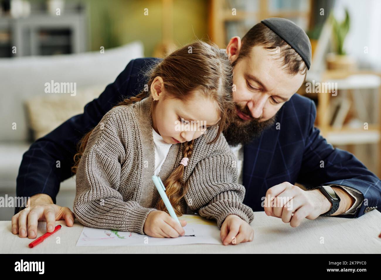 Porträt eines fürsorglichen jüdischen Vaters, der mit seiner Tochter zu Hause Bilder zeichnet Stockfoto
