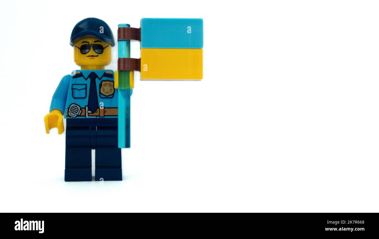LEGO Polizist mit der Flagge der Ukraine. Isoliert auf weißem Hintergrund. Mock-up, Kopierbereich. Konzept der Gerechtigkeit, des Friedens und der Freiheit Stockfoto
