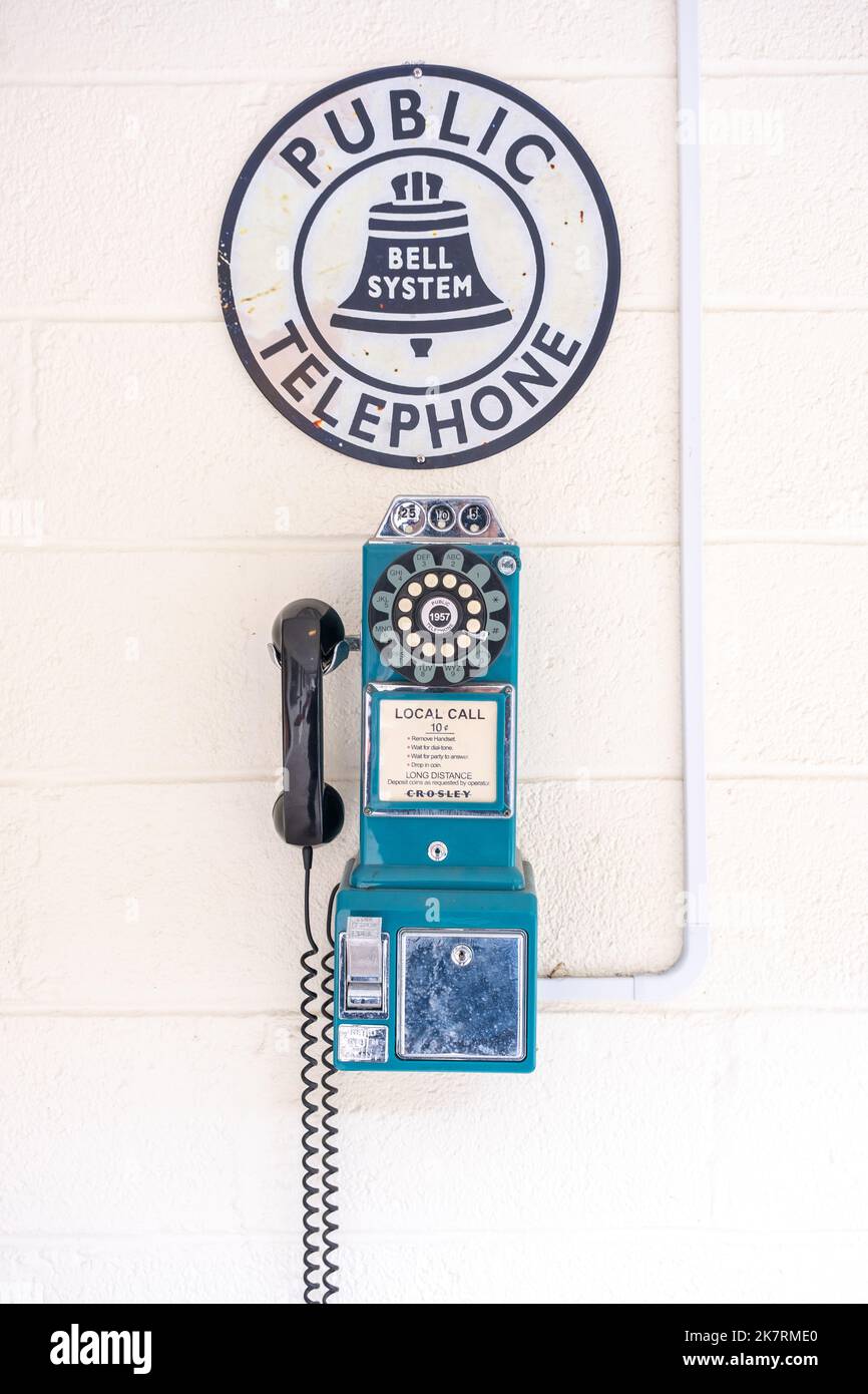 Retro bue Wand-Payphone von Crosley auf einer weißen Wand mit einem Bell System Public Telephone Schild oben gemacht. Stockfoto