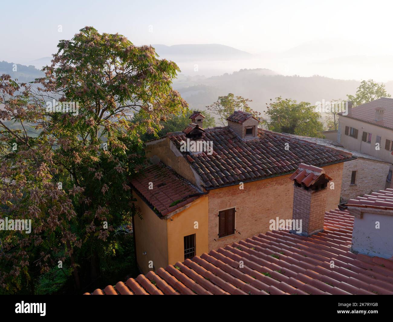 Nebeliger Blick von einem Haus in Coccore in der Region Le Marche in Italien über die umliegenden sanften Hügel und die Landschaft. Stockfoto