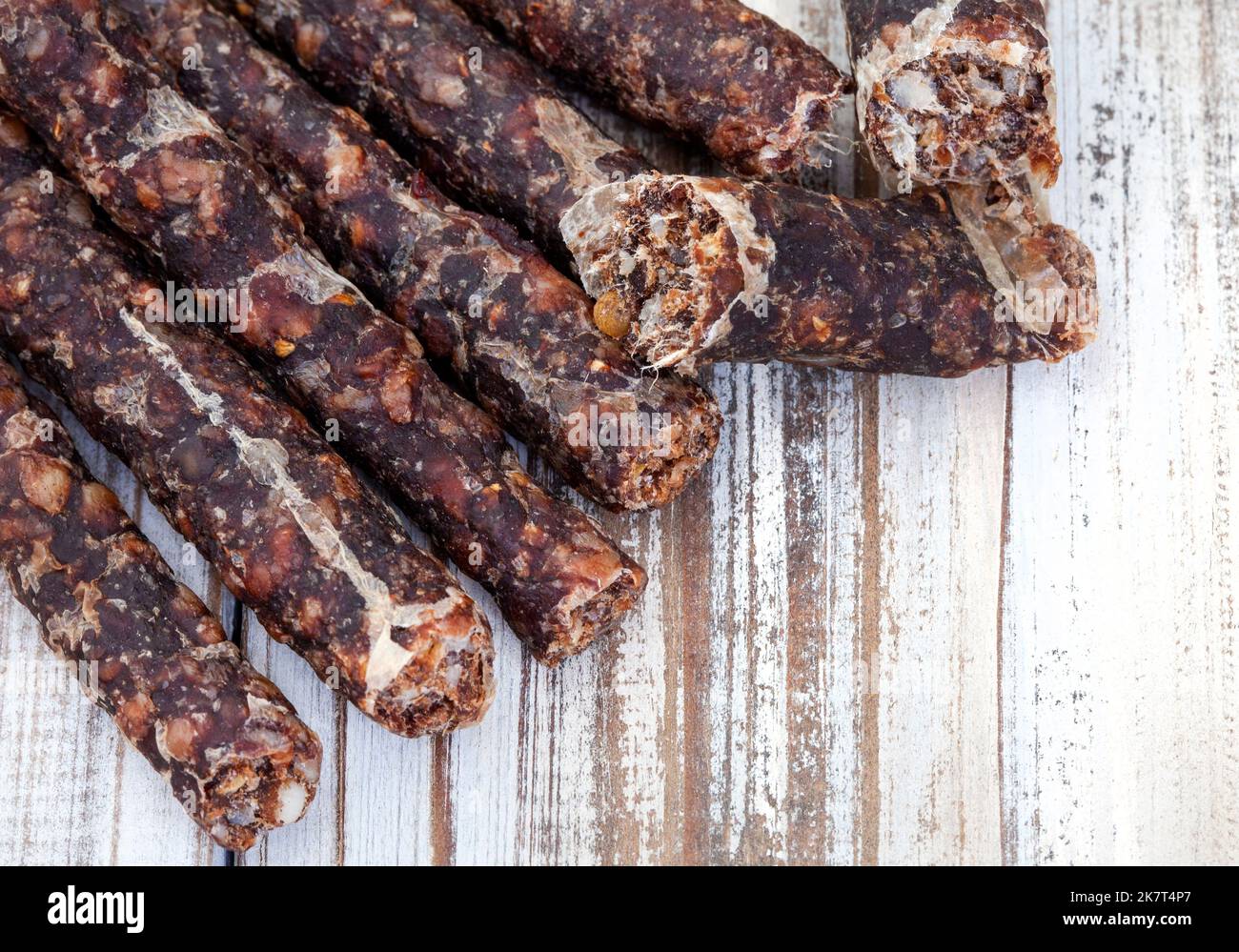 Traditionelle südafrikanische trockene Wurs liegen flach auf rustikalem weißen Holztisch mit Kopierfläche. Stockfoto