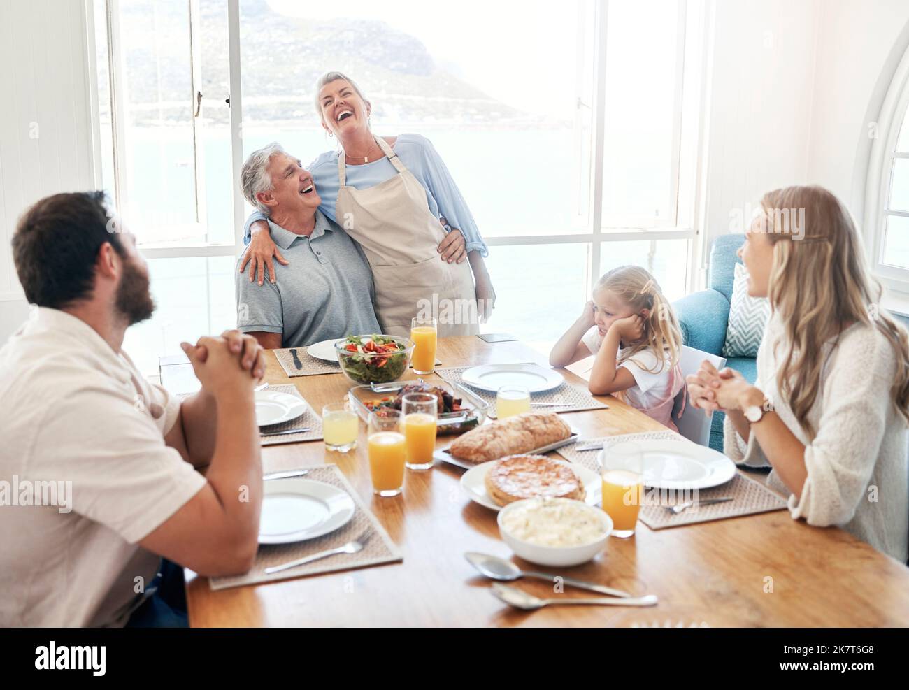 Frühstück, Kommunikation und große Familie essen zusammen am Esstisch ihres Hauses. Ältere Männer und Frauen sprechen über lustige Geschichte Stockfoto