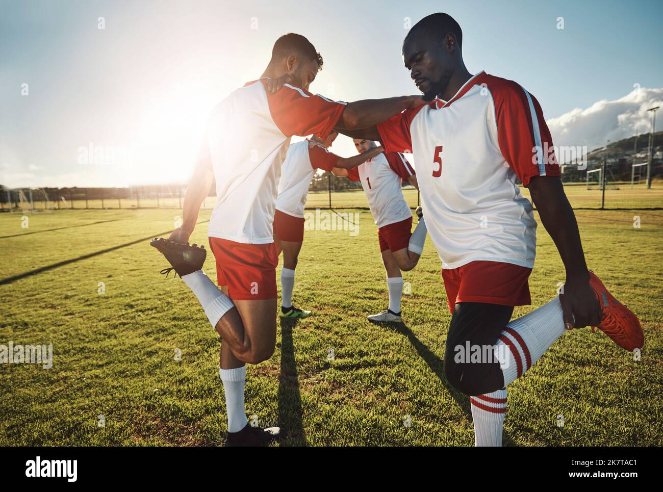 Fußball, Männer, die sich auf dem Spielfeld strecken, und Teamunterstützung vor dem Sportspiel oder dem Training. Gesundheit, Fitness und Teamarbeit, Fußballspieler Stockfoto