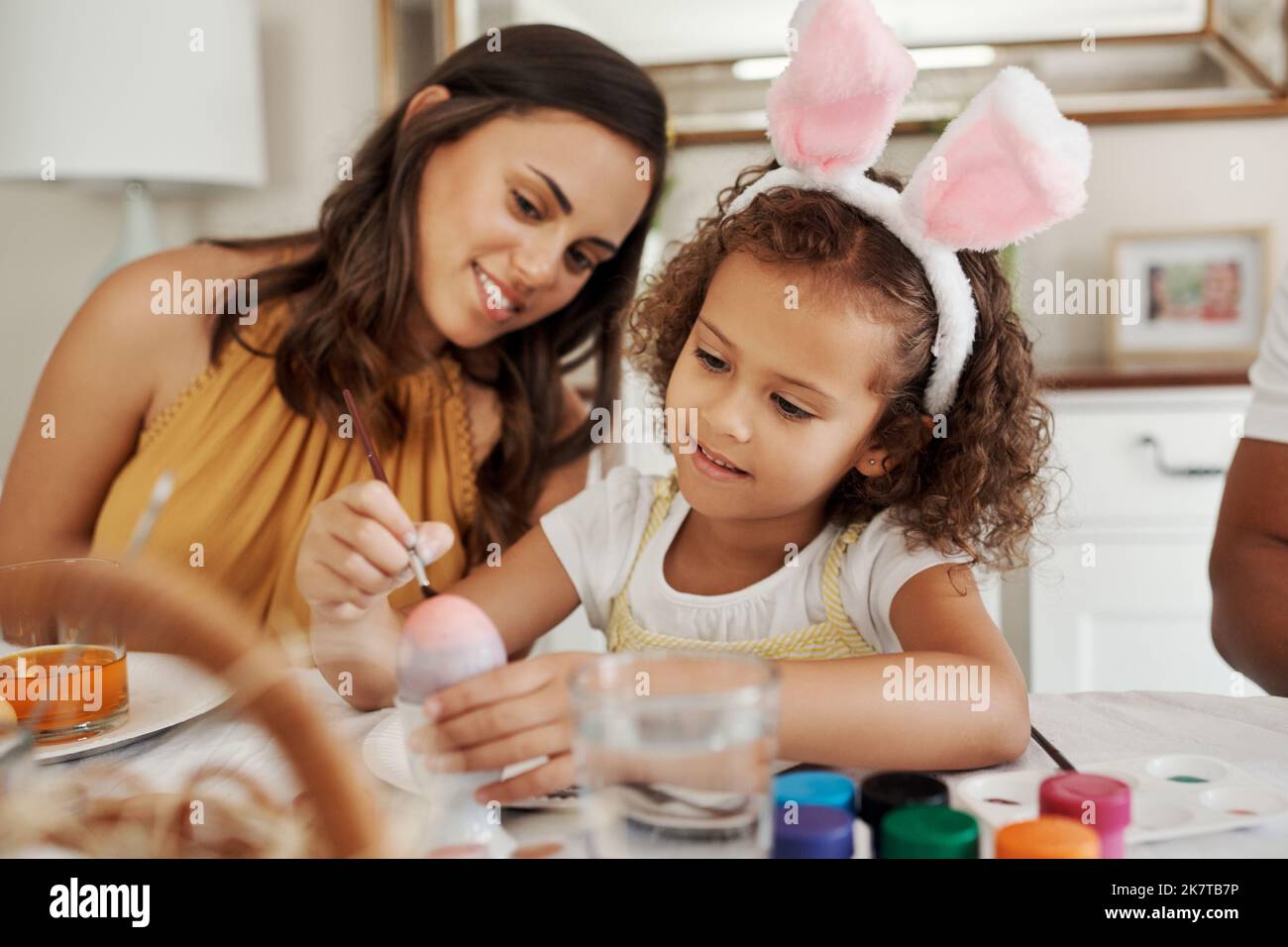 Welche Farben werden Sie verwenden? Eine Mutter malt mit ihrer Tochter Ostereier. Stockfoto