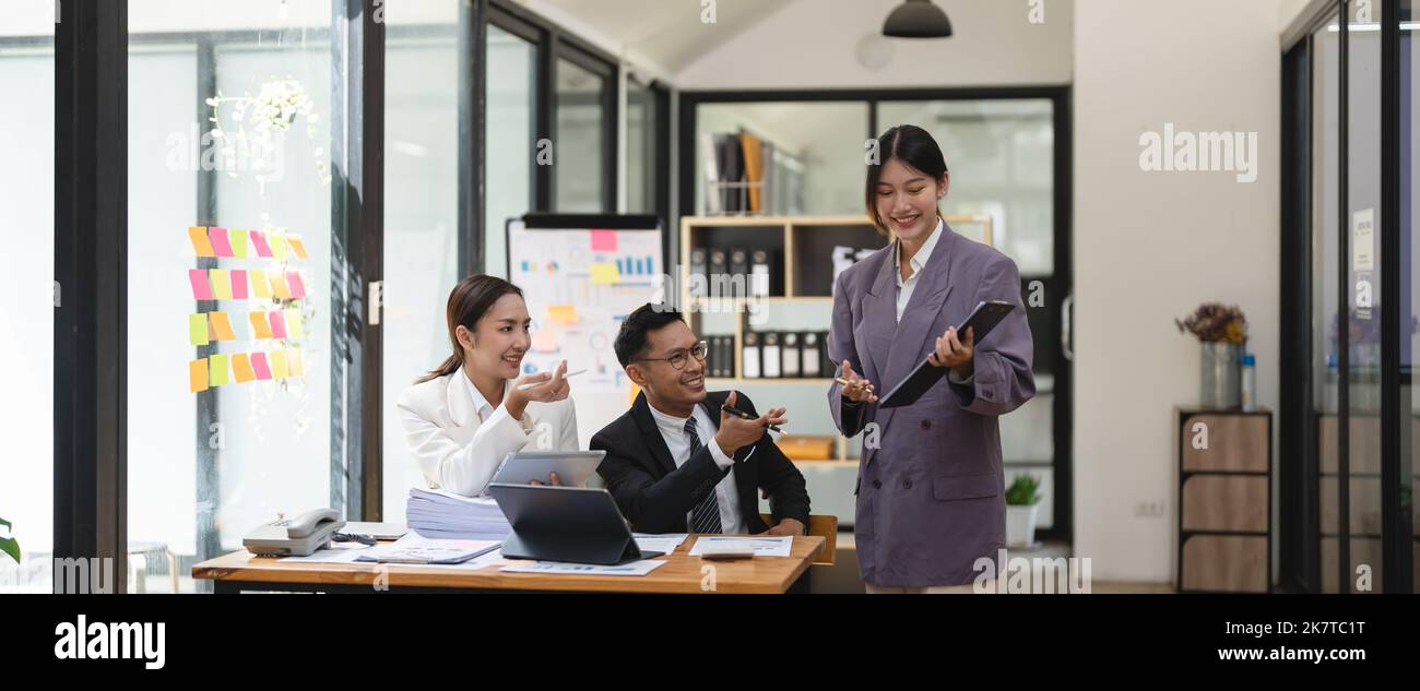 Geschäftsleute treffen sich und diskutieren Chart und Point-at-Chart Unternehmensbericht teilen Marketing im Büro. Das Business-Team steht zur Diskussion und zur Arbeit Stockfoto