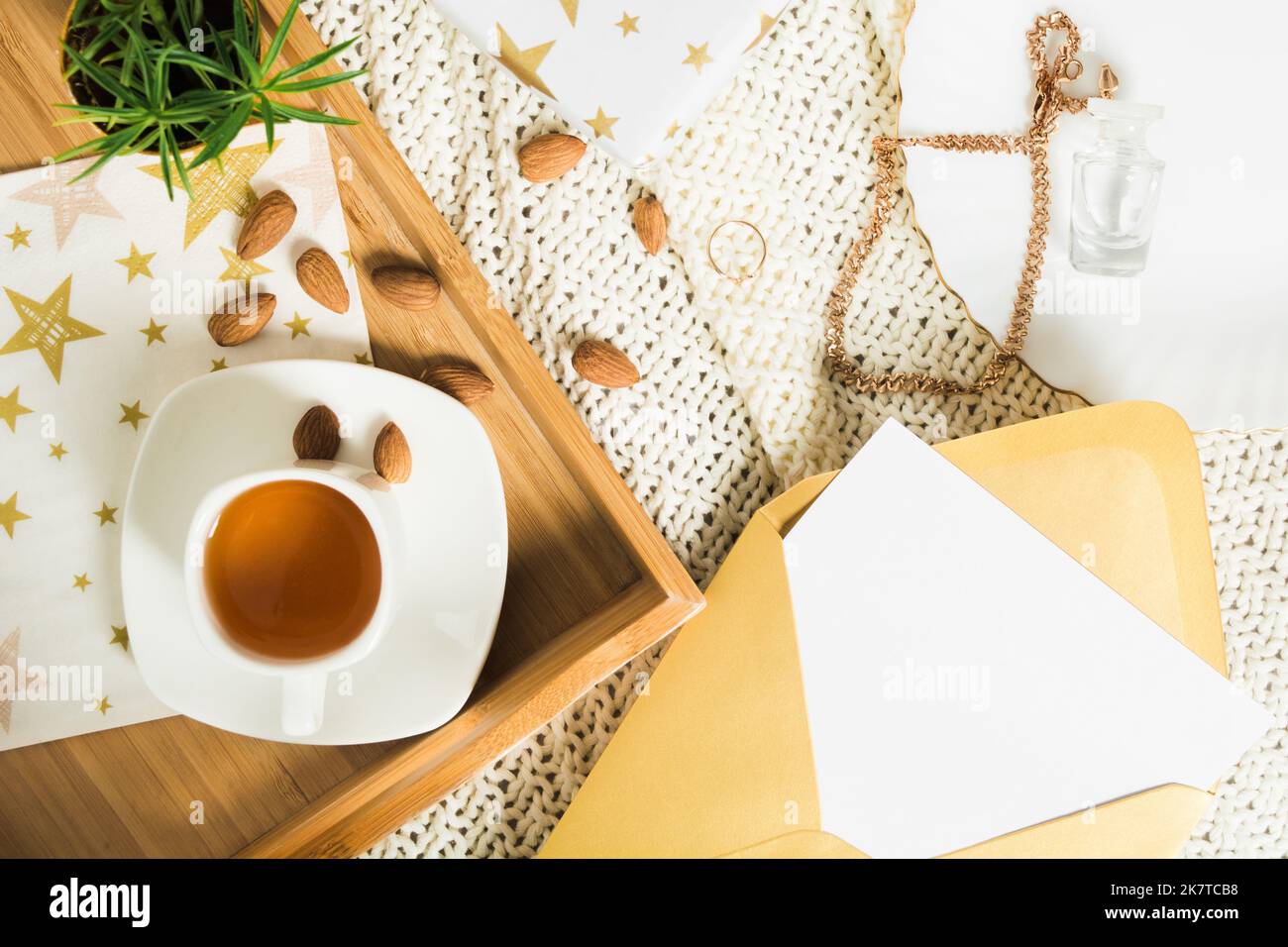 Herbst flach legen mit Tee auf Holztablett, Geschenkund Brief in goldenem Umschlag Stockfoto