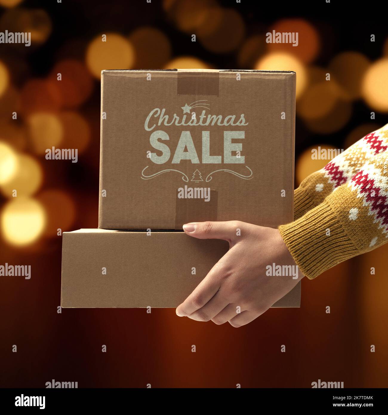 Frau hält Lieferkisten mit Geschenken und Bokeh Lichter im Hintergrund, Weihnachtsverkauf Konzept Stockfoto
