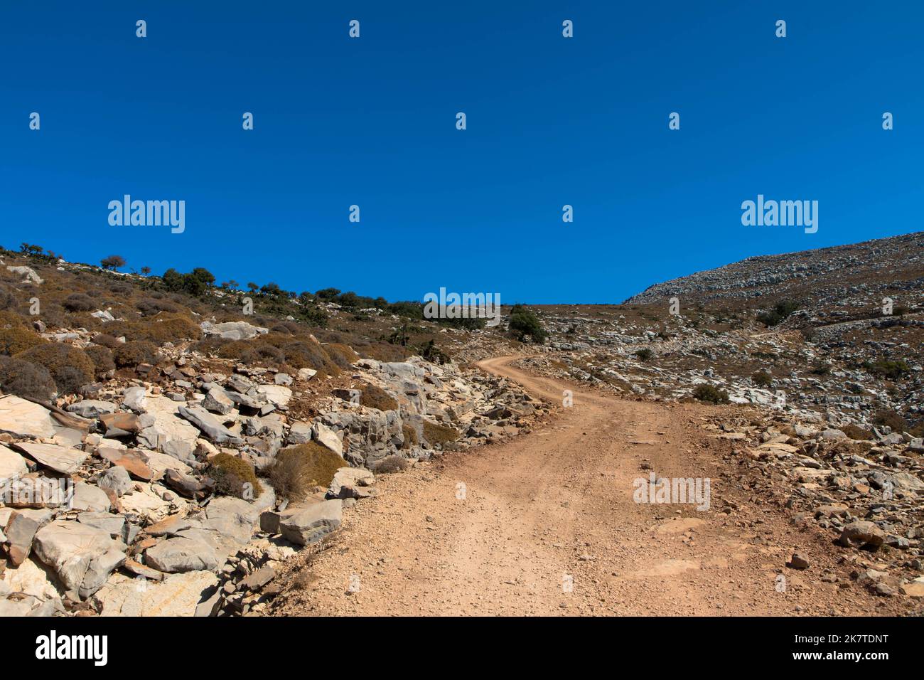 Schotterstraße zum Gipfel des Berges Attavyros. Die Landschaft ist sehr verwaist und der Himmel ist blau. Schönes Wandergebiet auf der Insel Rhodos Stockfoto