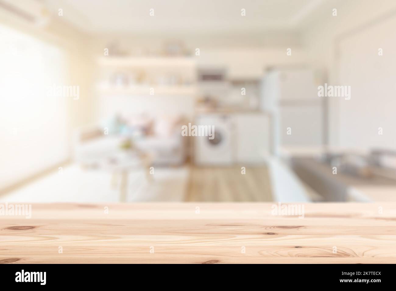 Verwischen Sie die Inneneinrichtung eines Hauses mit einem Holztisch für Wohnhausgeräte, dessen Hintergrund für die Montage von Produkten steht. Stockfoto
