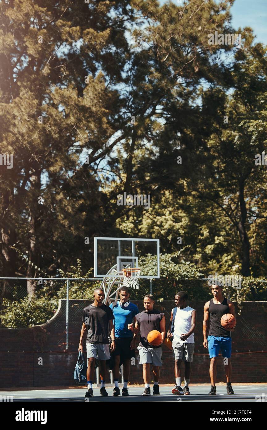 Sport, Freunde und Basketballtraining auf dem Basketballplatz mit einer Gruppe von Männern, die vor einem Spiel spazieren, reden und sich miteinander verbinden. Mann, Team und Sport Stockfoto