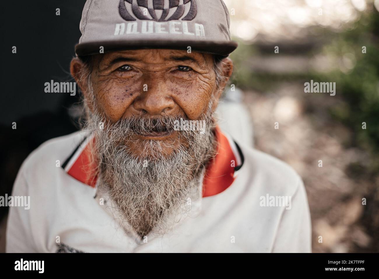 Porträt eines alten balinesischen Mannes in einem alten Pullover und einer Mütze. Indonesien, Bali, 27. September 2022. Stockfoto
