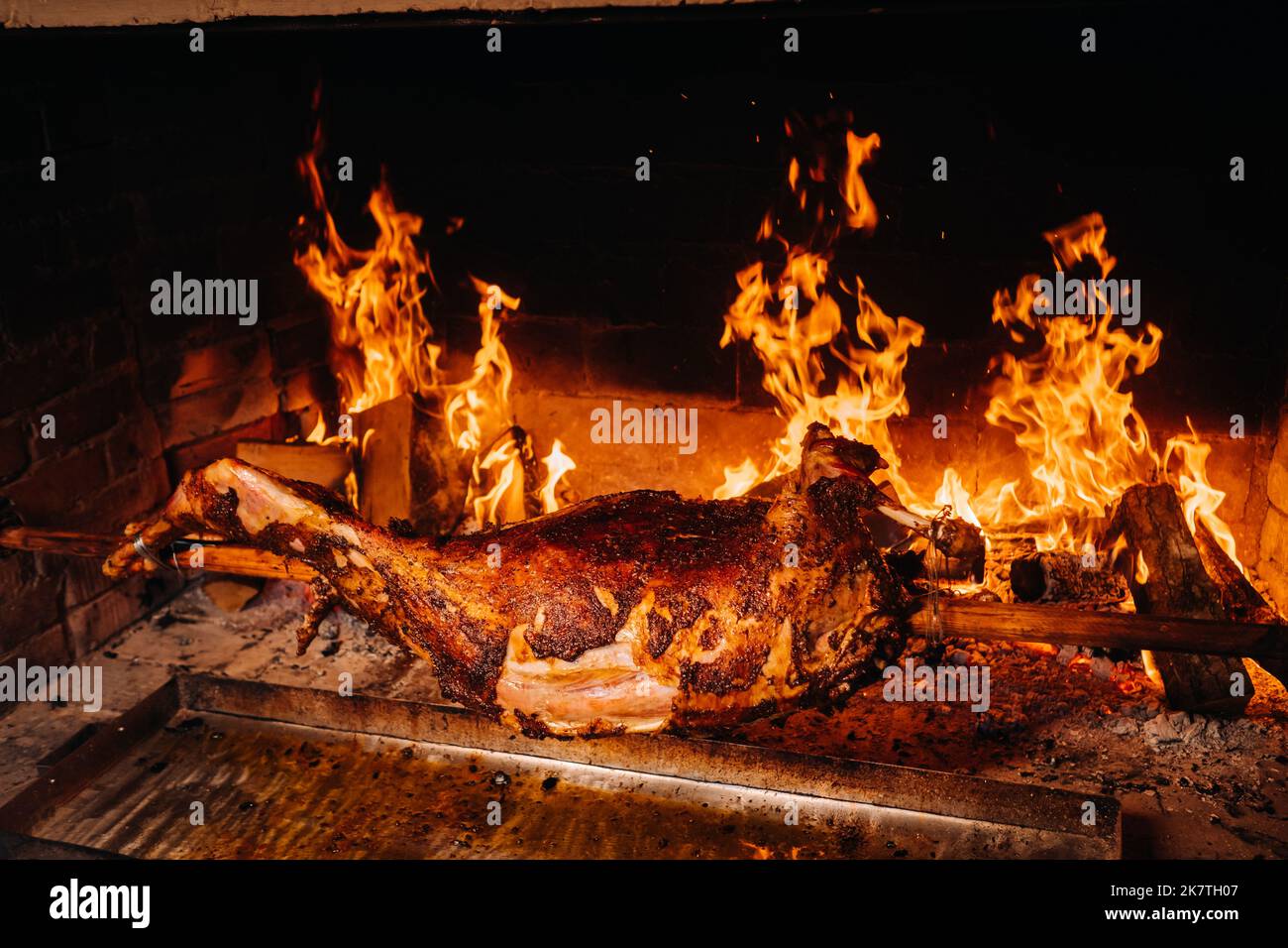 Das Lamm wird komplett auf einem Spieß auf dem Feuer gekocht. Kochen Stockfoto