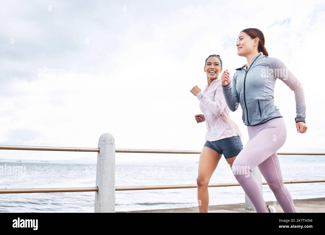 Laufen, Fitness und Freunde, Frauen laufen am Strand, Bewegung und Cardio, Ausdauer und einen aktiven Lebensstil. Junge, glückliche Menschen, Läufer und Gesundheit Stockfoto