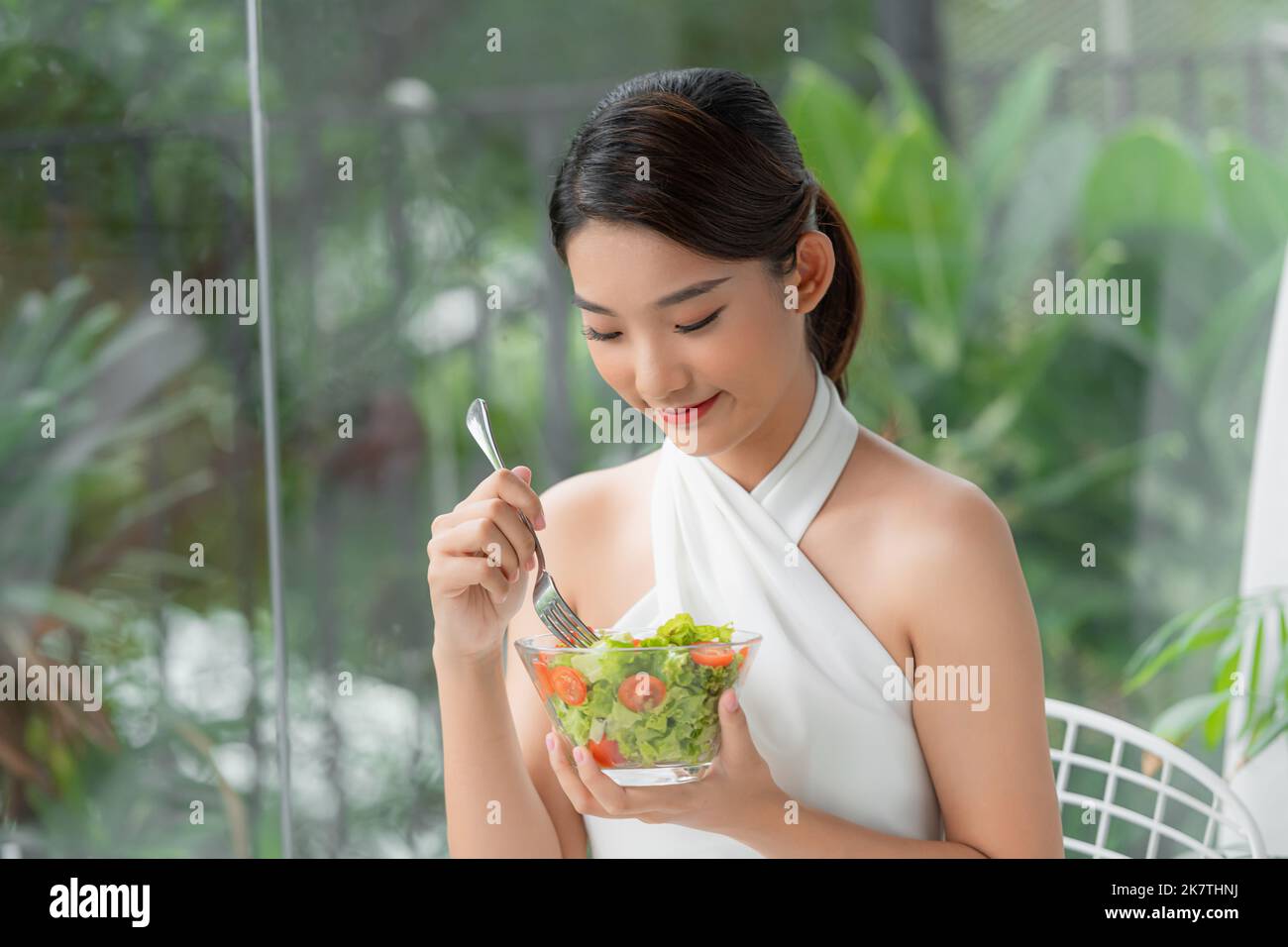 Junge attraktive asiatische Frau, die isst Stockfoto