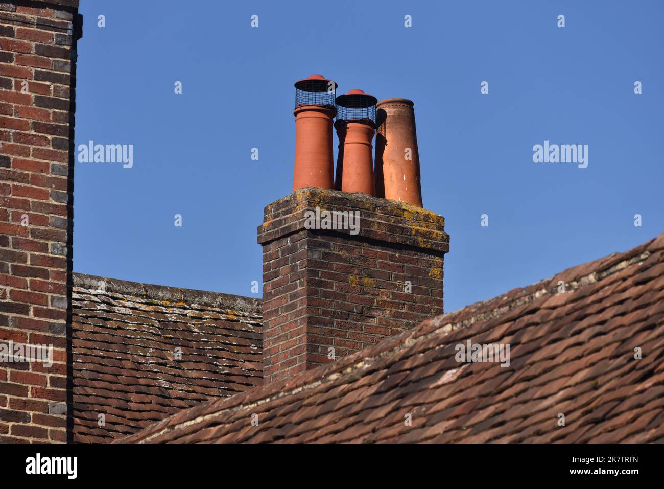 In einem ländlichen Dorf in Hampshire, England, befindet sich ein alter Ziegelkamin mit Keramiktopf auf der Oberseite. Stockfoto