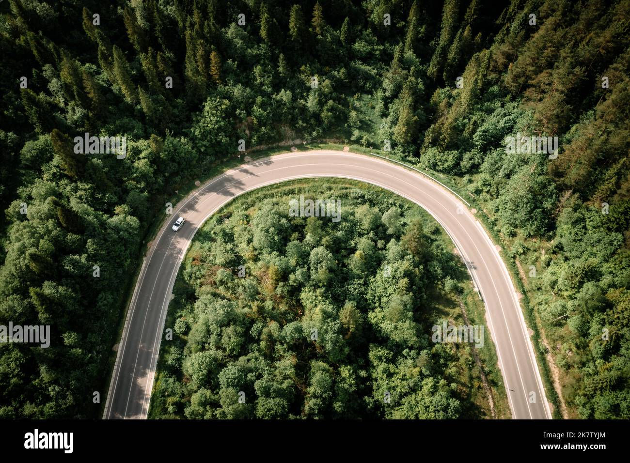 Flug über die Sommerberge mit Bergstraße Serpentin und Wald. Ukraine, Karpaten. Landschaftsfotografie Stockfoto