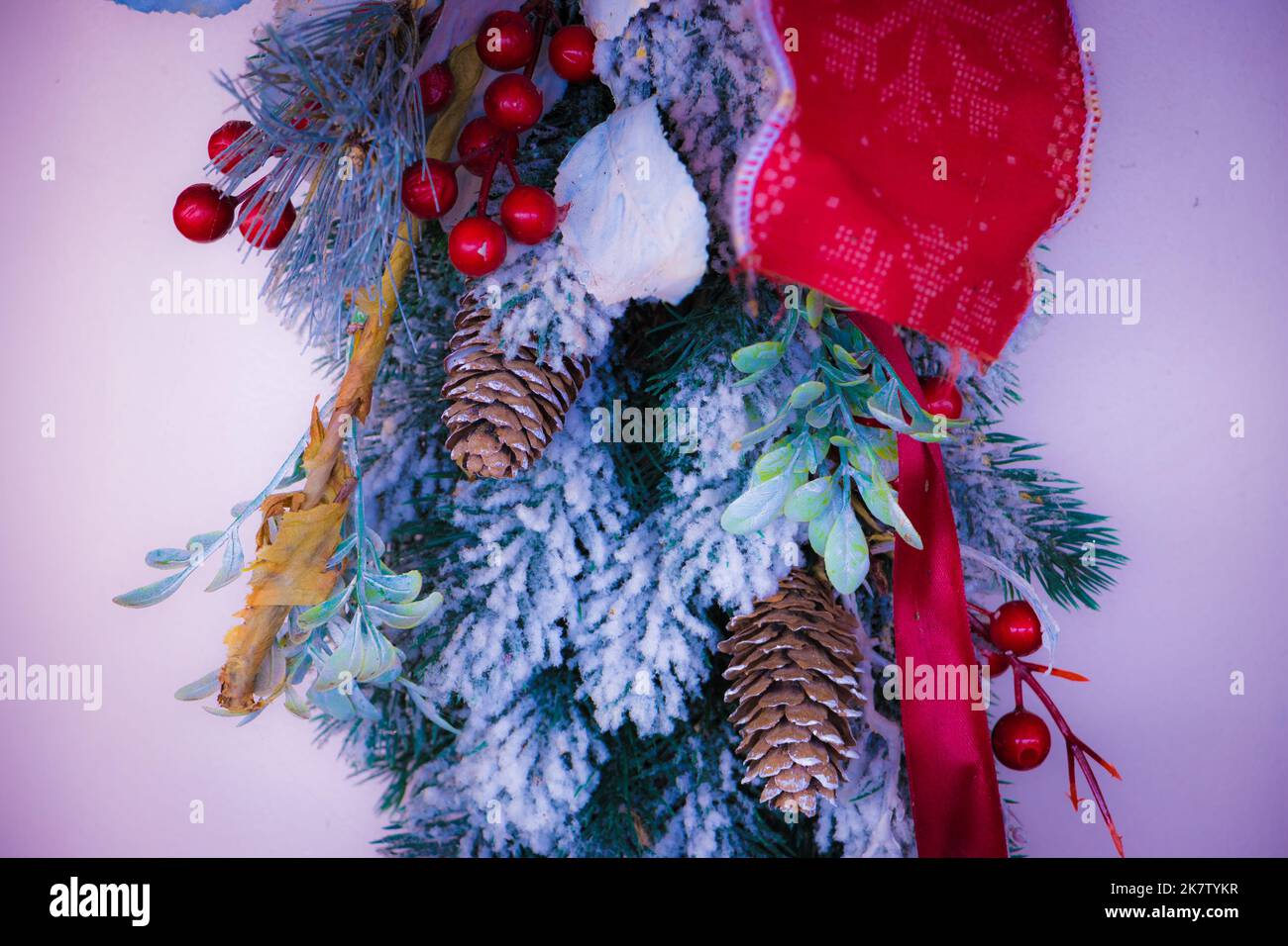 Weihnachtliche Dekoration mit Schnee, Evergreens, Kegelbällen und Feiertagsmotiven. Goldenes und rotes Band. Frohes neues Jahr und frohe Weihnachten. Stockfoto